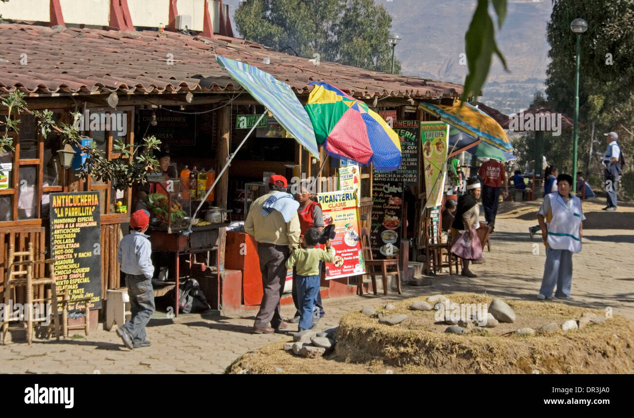 Restaurant with indigenous family strolling past menu boards in mountain city of Ayacucho in Peru South America Stock Photo