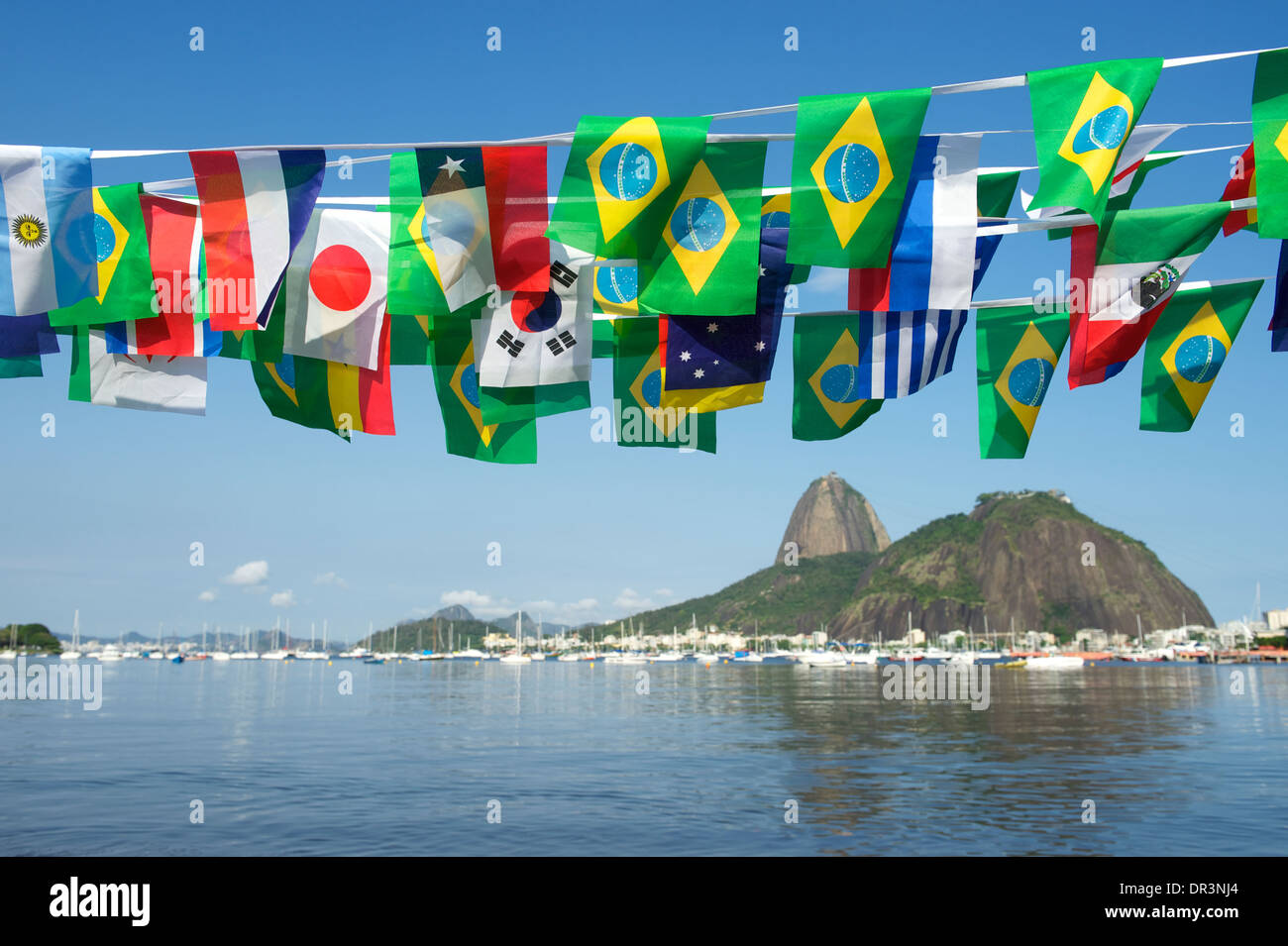 Brazilian and international flags bunting decoration above Sugarloaf Pao de Acucar Mountain Rio de Janeiro scenic sea view Brazi Stock Photo