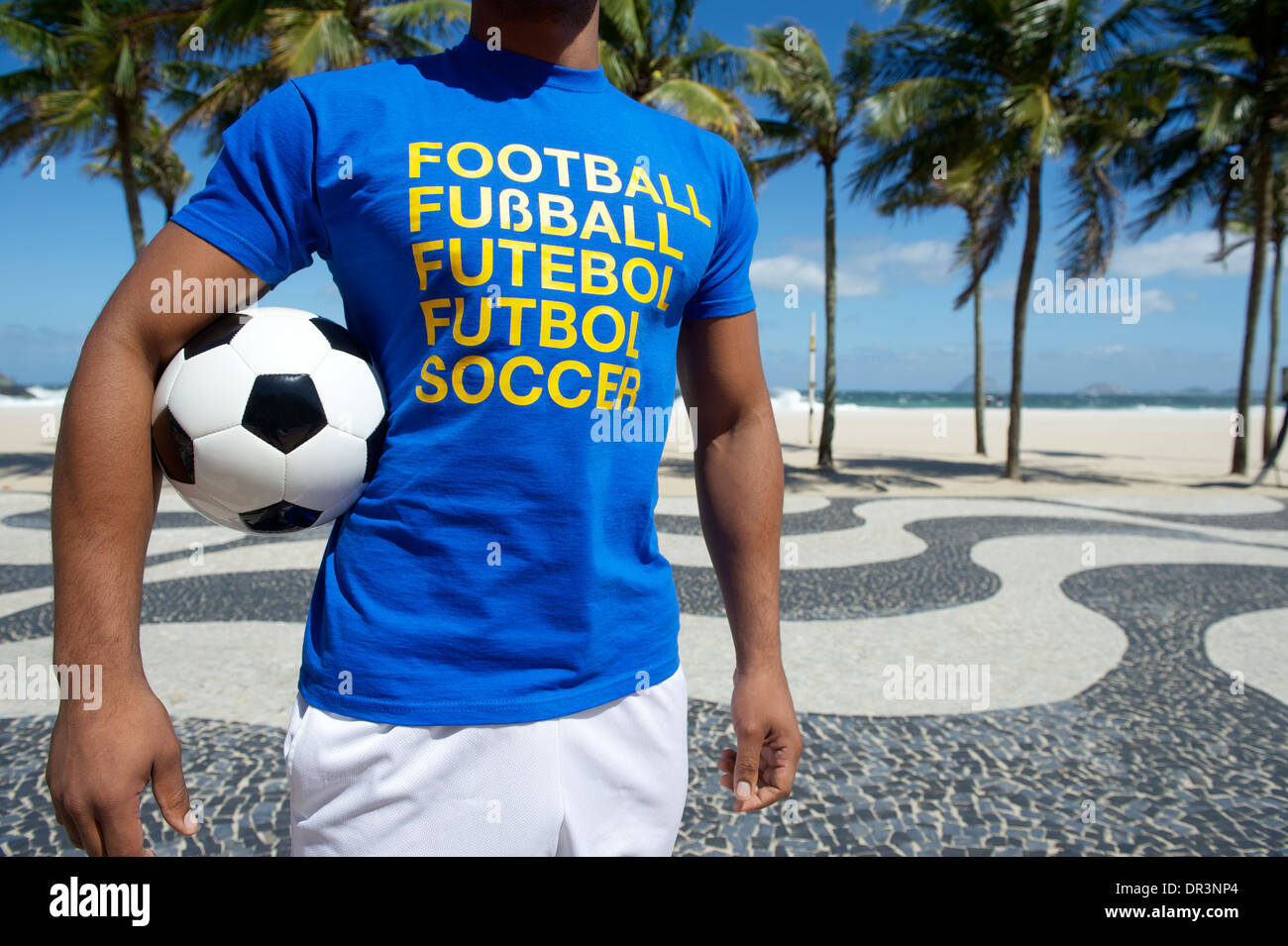 Brazilian soccer player wearing international football shirt holding soccer ball at Copacabana Beach Rio de Janeiro Stock Photo
