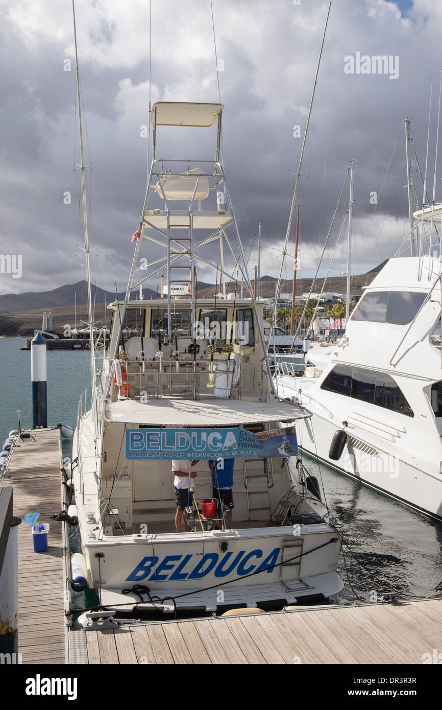 Tourists' charter fishing boat equipped with rods moored in the marina in Puerto Calero, Lanzarote, Canary Islands, Spain Stock Photo