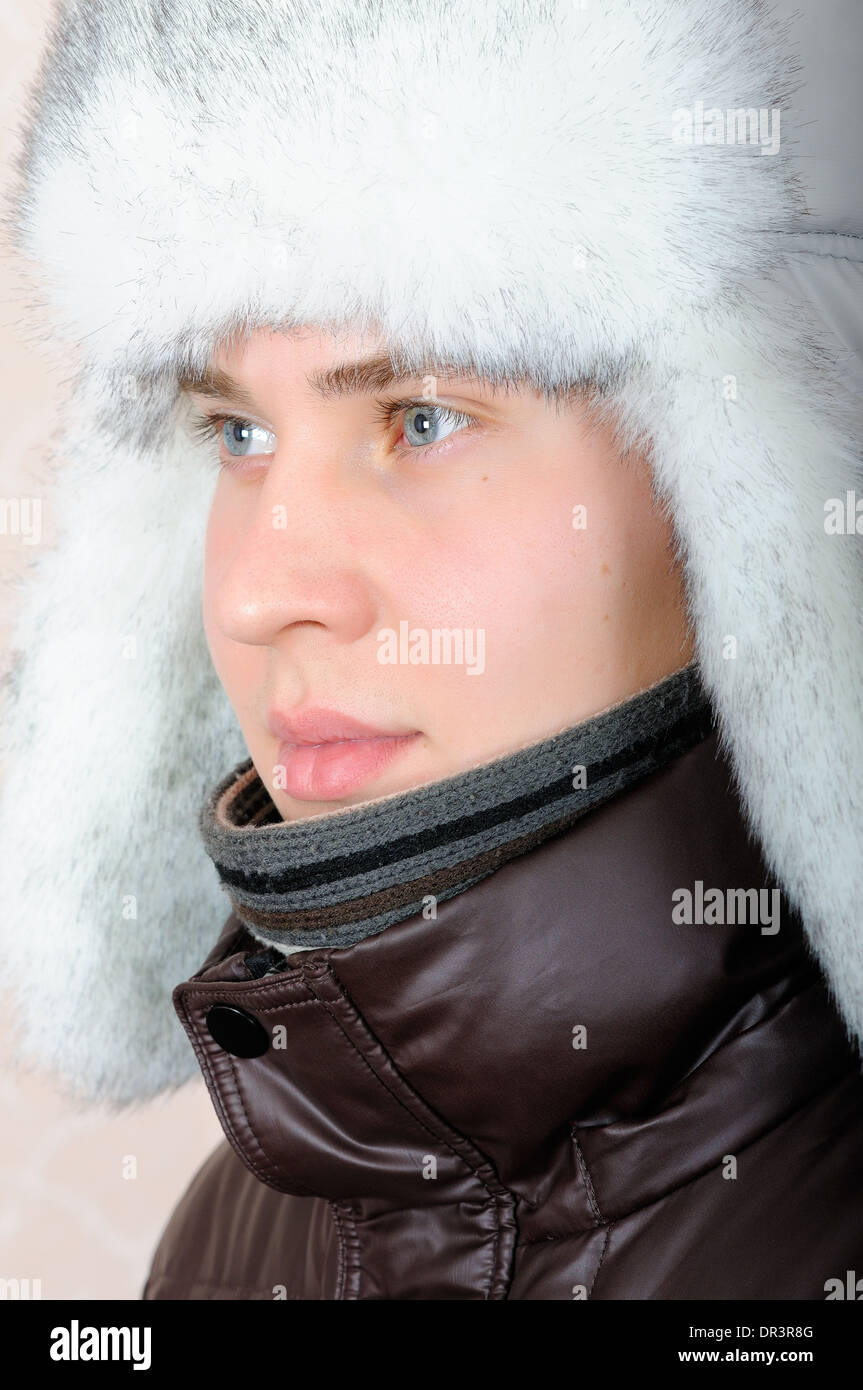 Portrait of teenage boy with blue eyes in winter hat with white fur Stock Photo