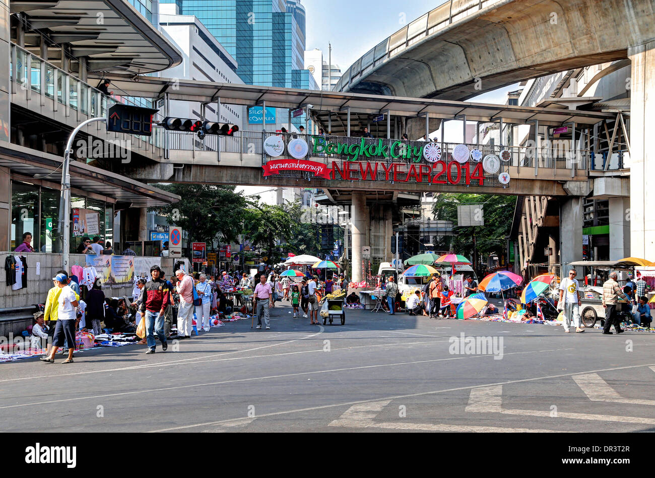 Bangkok, Thailand. 19th Jan 2014. Location in these images is at the normally busy Silom-Saladaeng intersection in one of Bangkoks key commercial districts. Tens of thousands of protesters have disrupted traffic at major intersections and marched on government offices in Thailand's large and hectic capital city this week. The protests, dubbed 'Bangkok Shutdown,' had begun Monday 13th January without serious incident.  The rallies are orchestrated by the People's Democratic Reform Committee (PDRC) protest group, led by Suthep Thaugsuban, a former deputy prime minister for the opposition Democ  Stock Photo