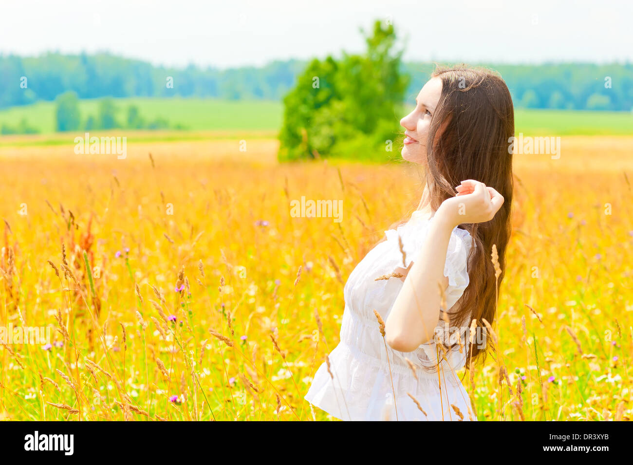 happy woman in a white sundress in the field Stock Photo