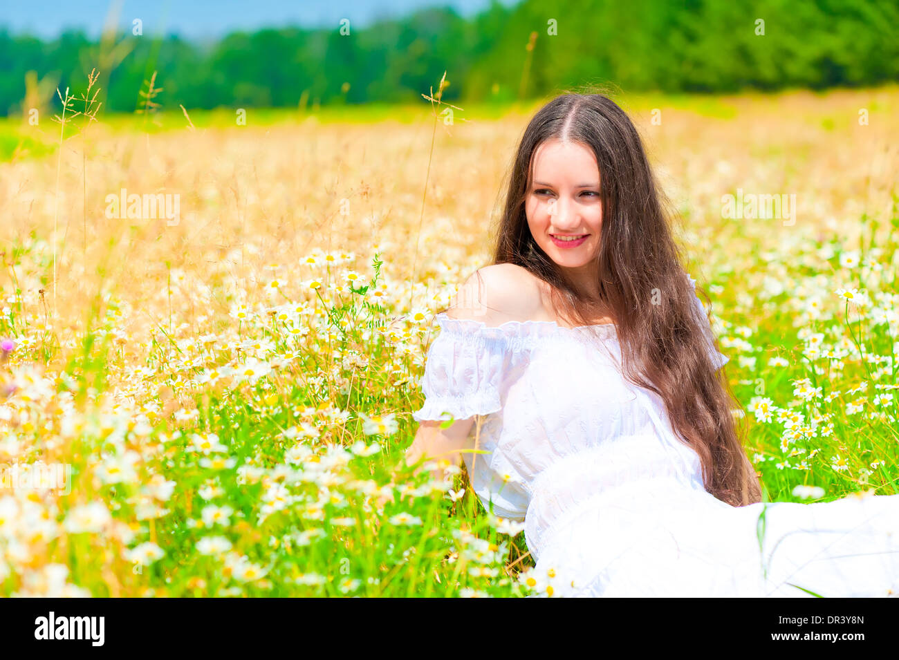 happy young girl lying in a field with daisies Stock Photo