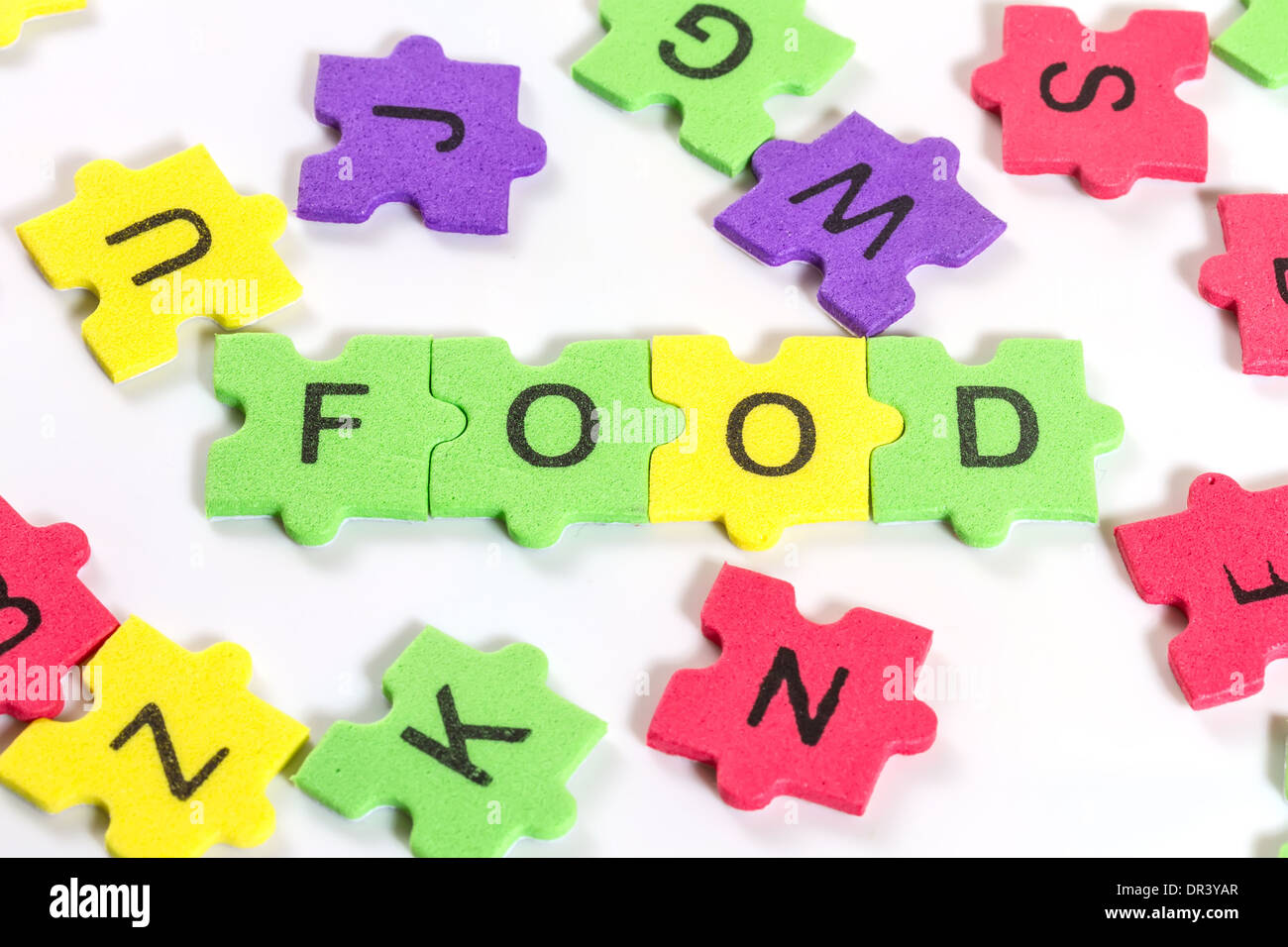word FOOD formed with colorful foam puzzle on white background Stock