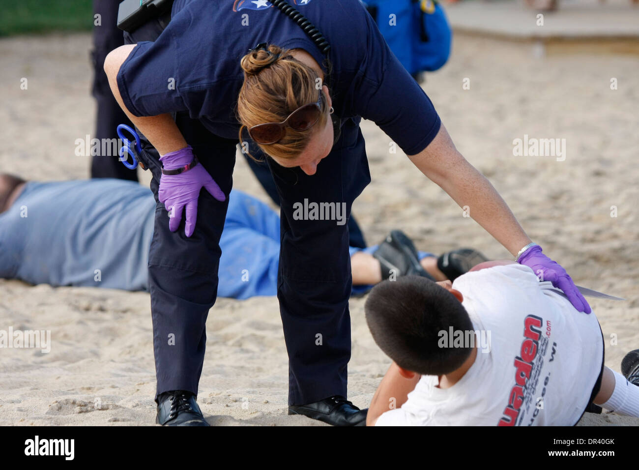 An EMT at a scene of a mass casulty incident is checking on one of the victims Stock Photo