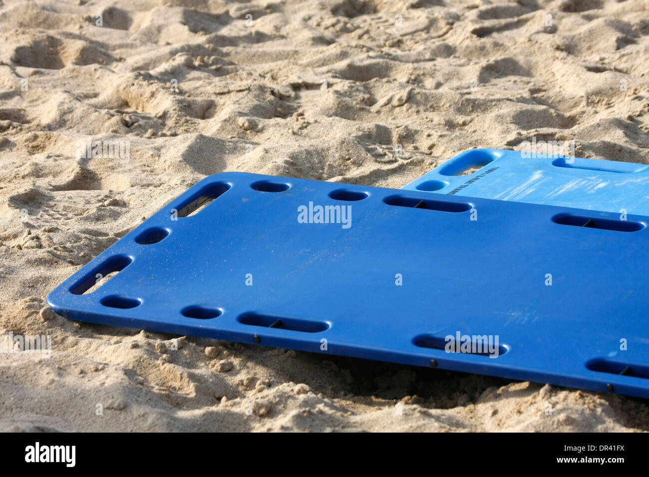 EMS medical backboards laying in the sand at a site of a mass casualty