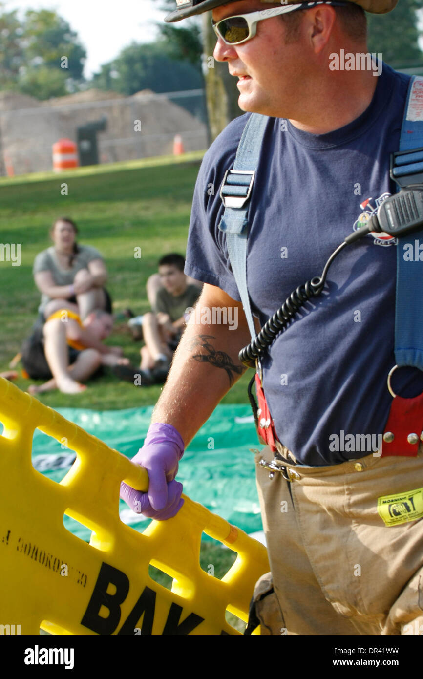 A firefighter emt holding a backboard rushing at a scene of a mass casualty incident Stock Photo