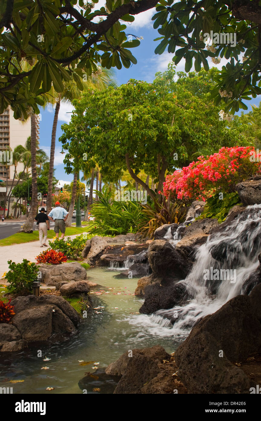 Flowers and waterfall fountain at Kuhio Beach Park, Waikiki Beach, Honolulu, Oahu, Hawaii Stock Photo