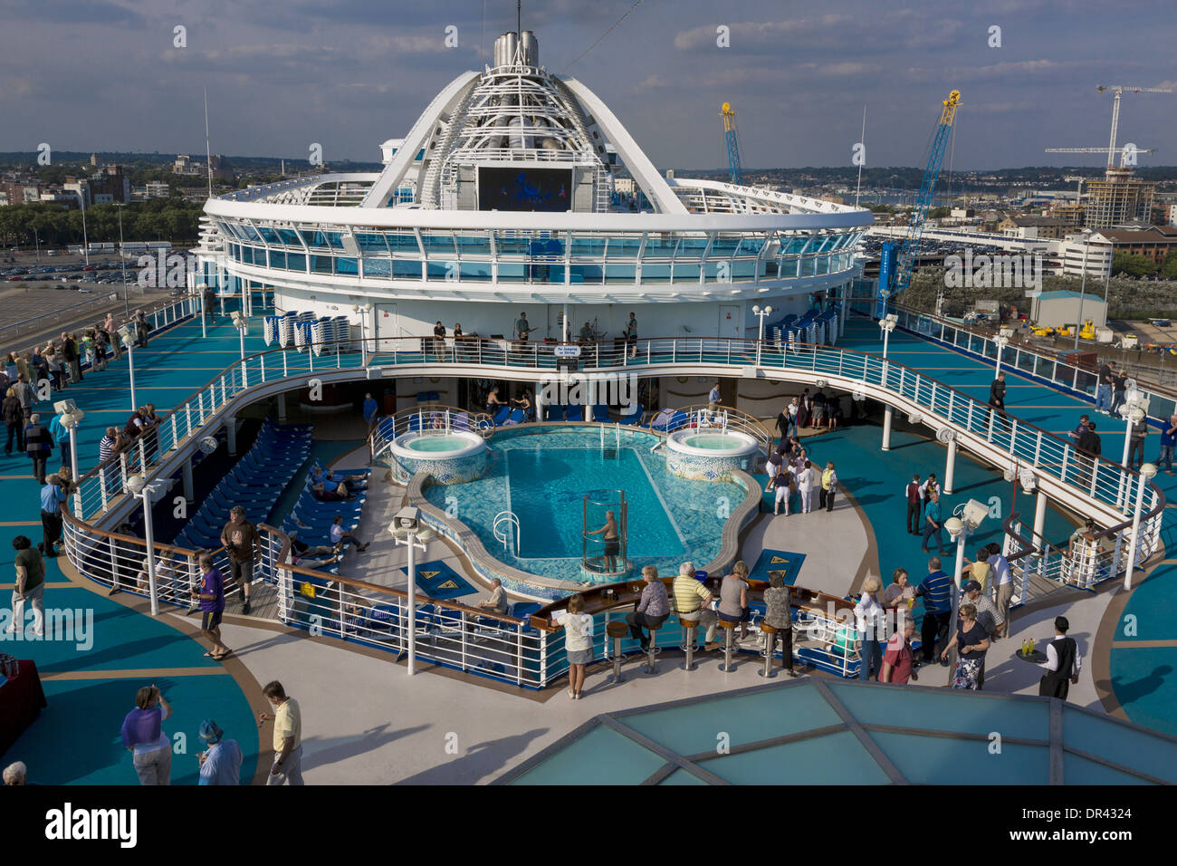 Cruise ship deck. Passengers wandering around the pool deck of the Caribbean Princess before leaving Southampton Stock Photo