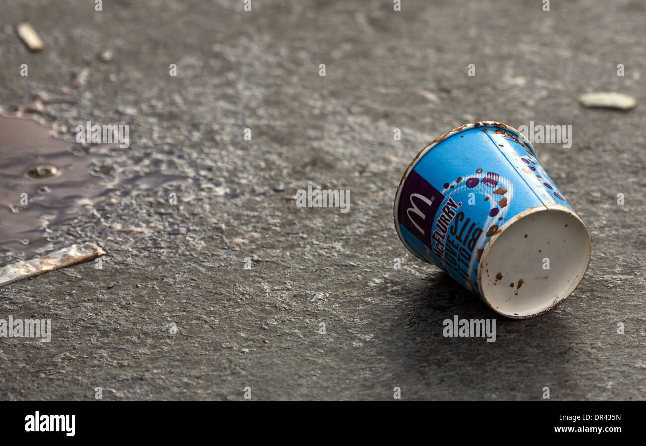 Discarded McDonalds McFlurry ice cream container lying on a wet road Stock Photo