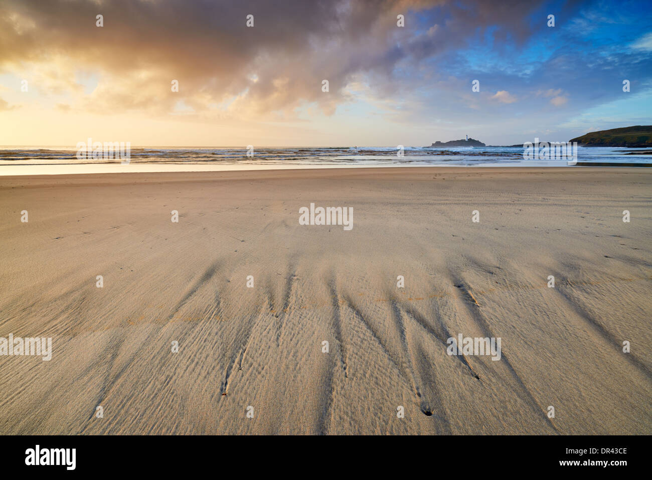 The evening shoreline at Gwithian beach with patterns in the sand left by the retreating tide Stock Photo