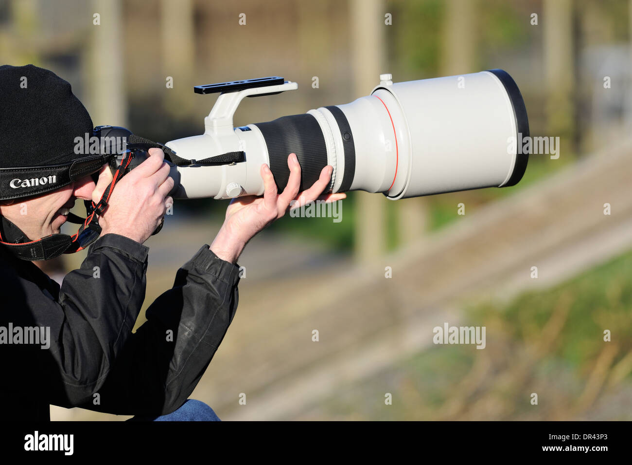 A young male using a modern digital slr camera and canon 600 mm f4 lens for capturing wildlife photographs Stock Photo