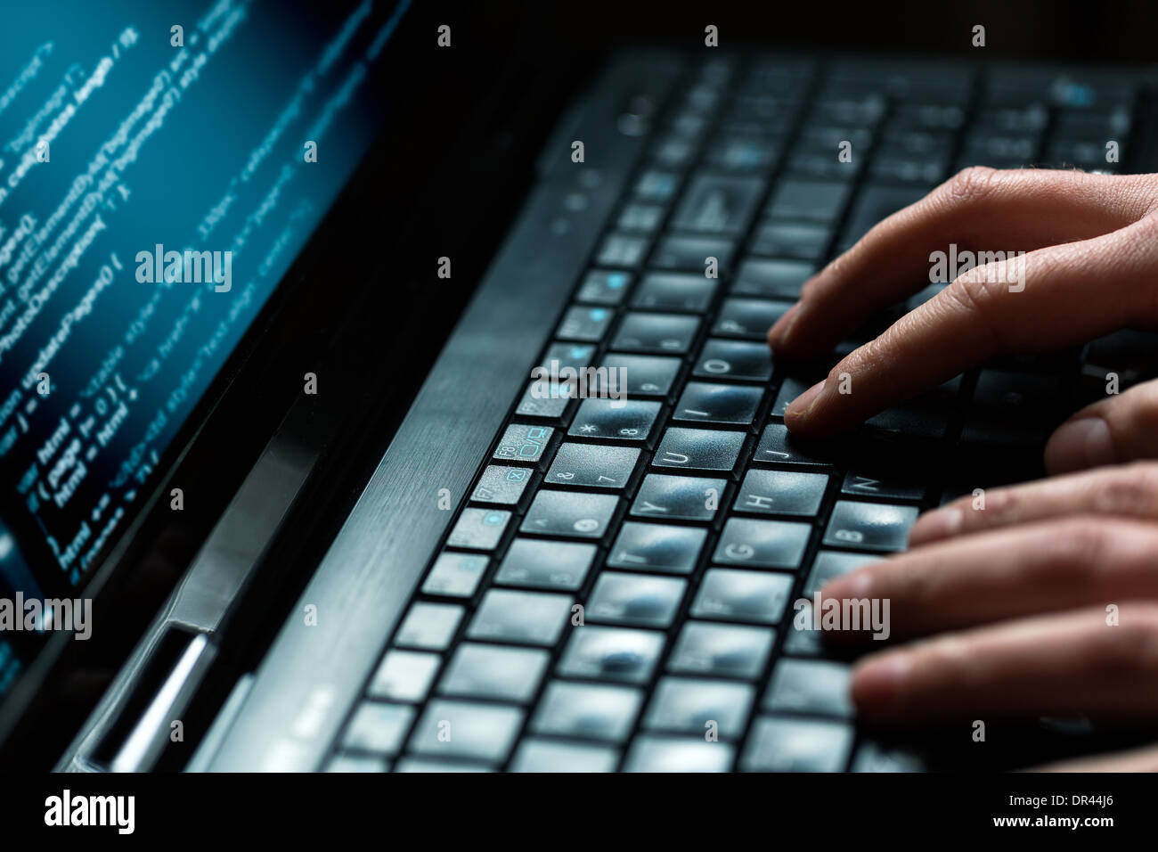 Hacker using laptop. Lots of digits on the computer screen. Stock Photo