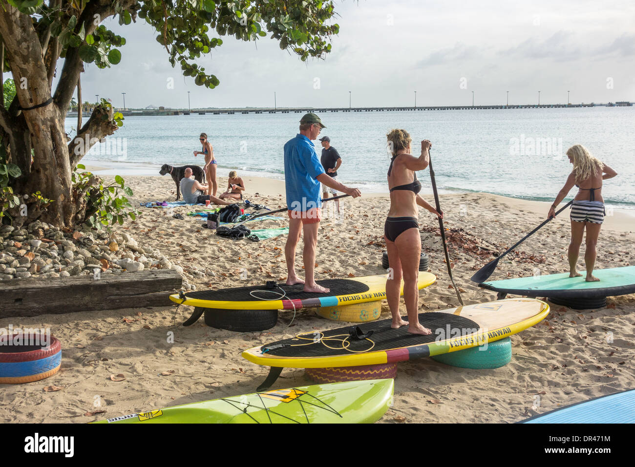 A female instructor instructs customers in the use of stand-up paddle boards on St. Croix, U.S. Virgin Islands. Stock Photo