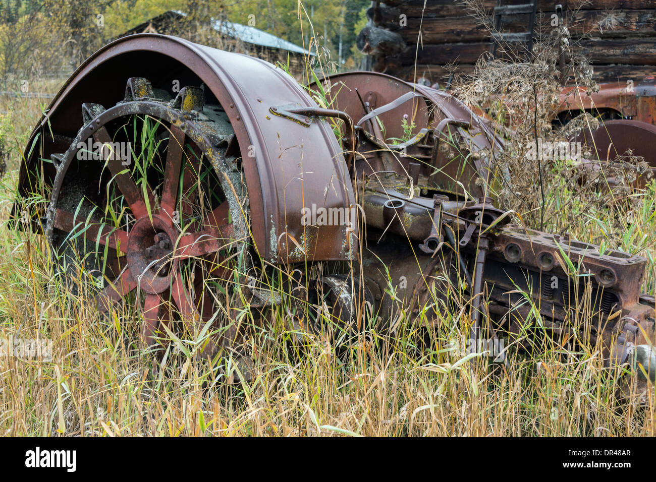 Abandoned old tractor wheels and engine block, on a farm near Likely, Cariboo-Chilcotin region, British Columbia Stock Photo