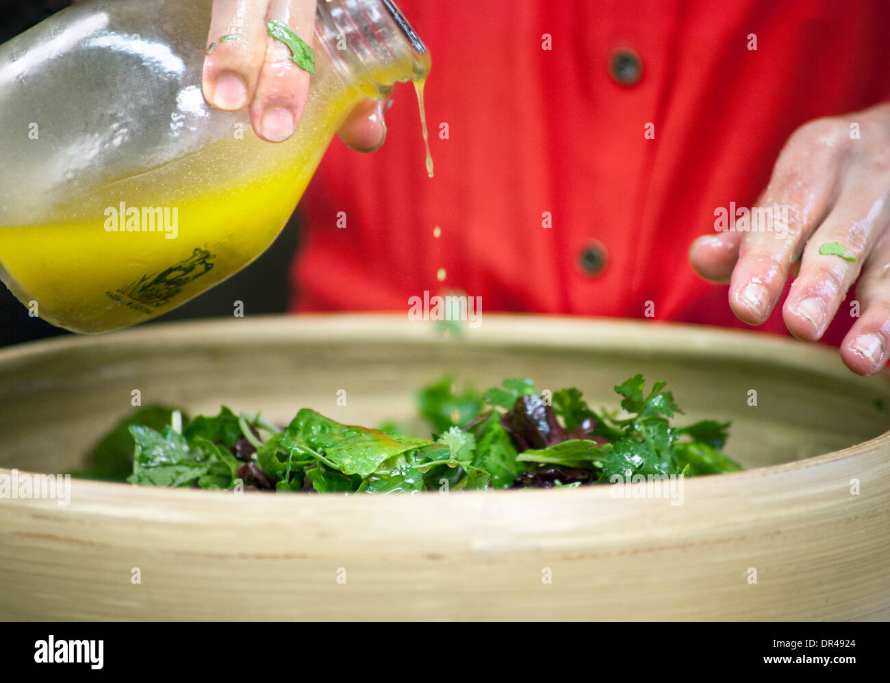 Dressing being poured over a salad Stock Photo