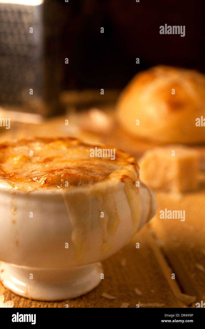 French onion soup with grated cheese and a round loaf of French bread Stock Photo