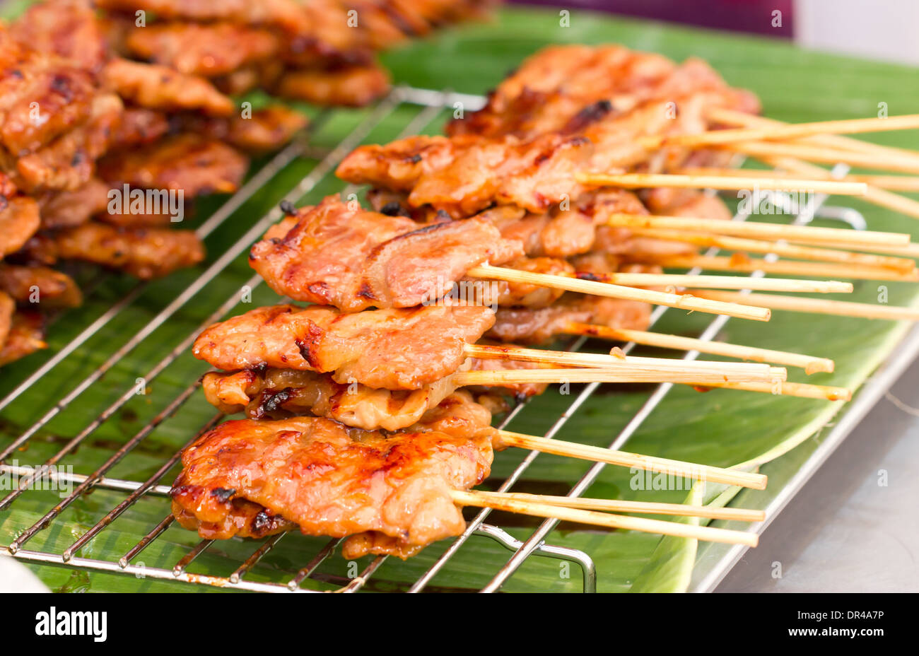 Thai style BBQ pork on metal sieve. Stock Photo