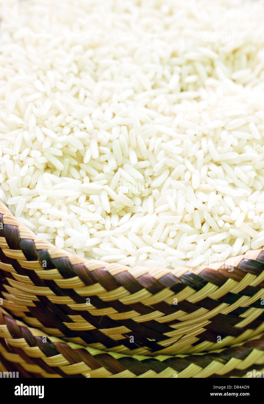 Uncooked rice in bamboo basket. Stock Photo