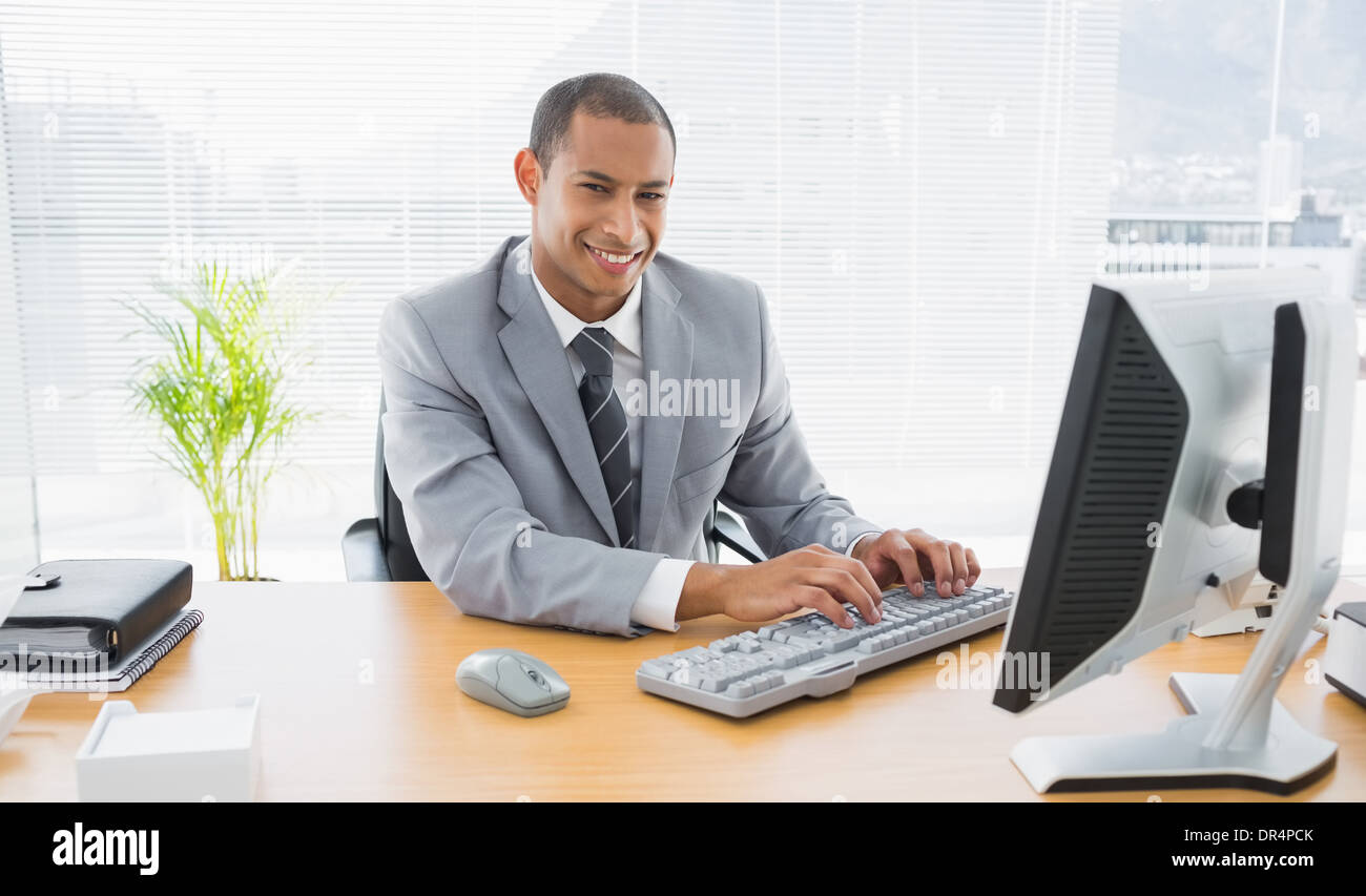 Smiling businessman using computer at office Stock Photo