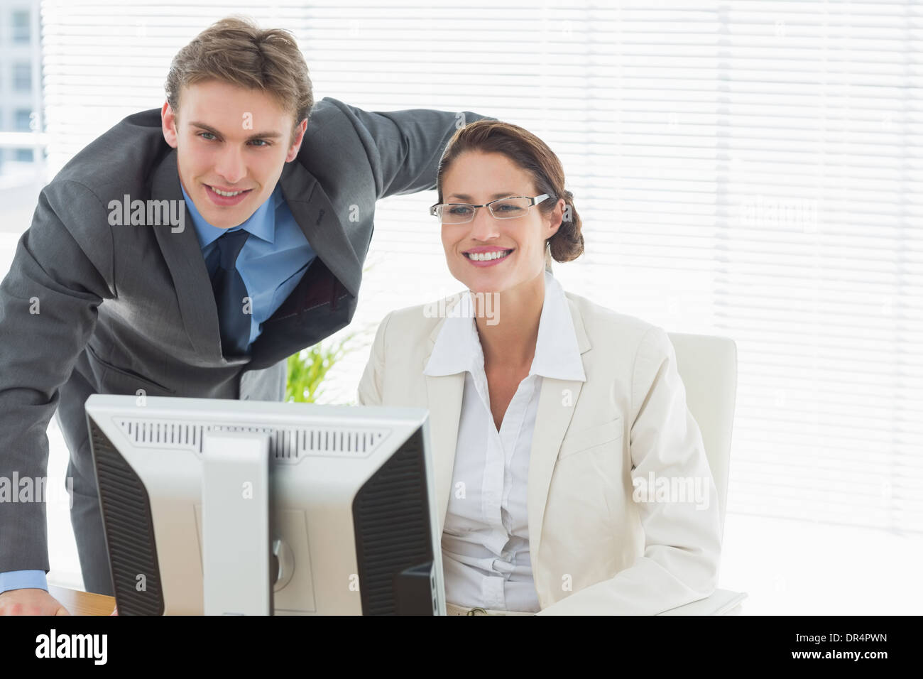 Confident smiling business couple with computer Stock Photo