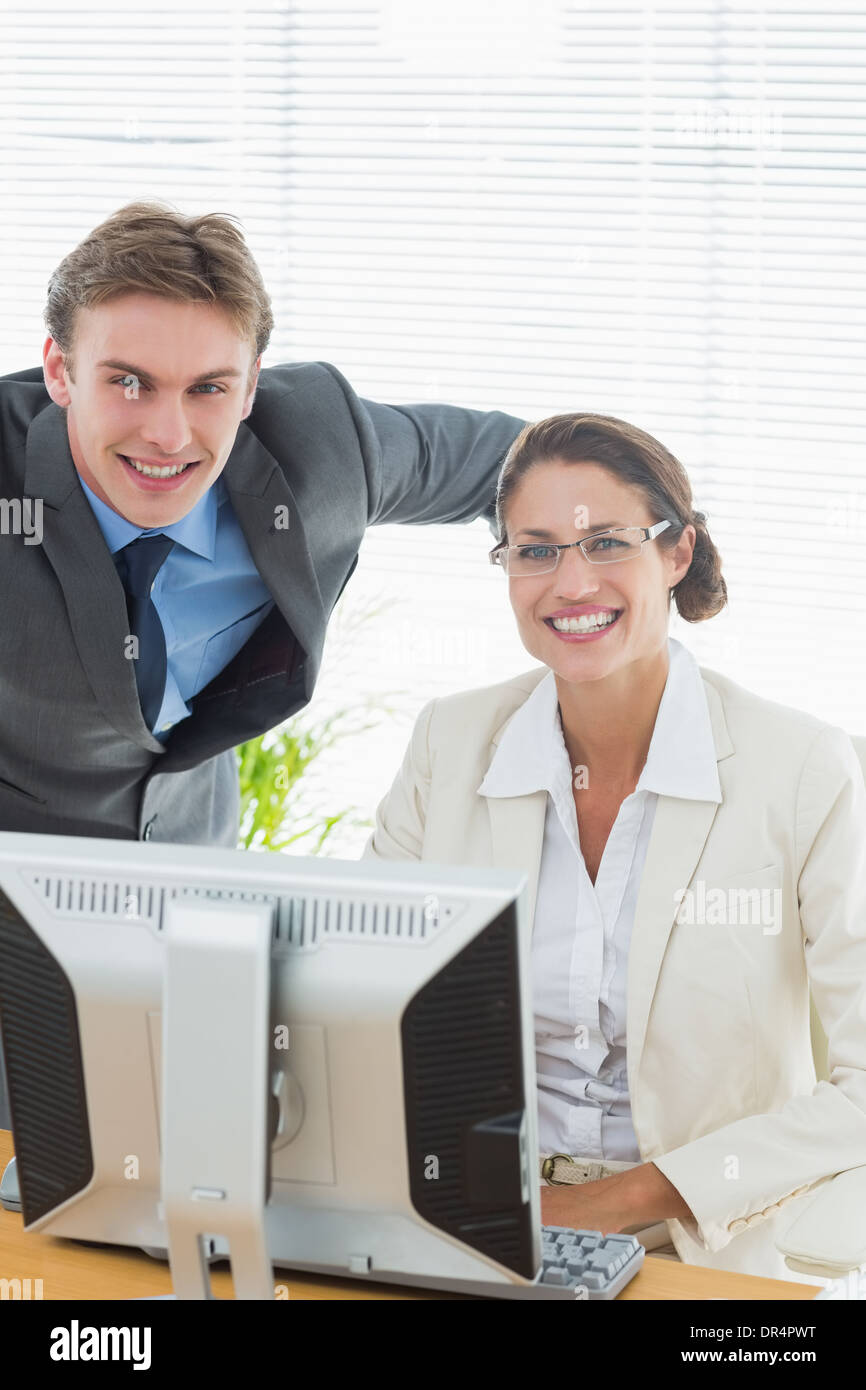 Confident smiling business couple with computer Stock Photo
