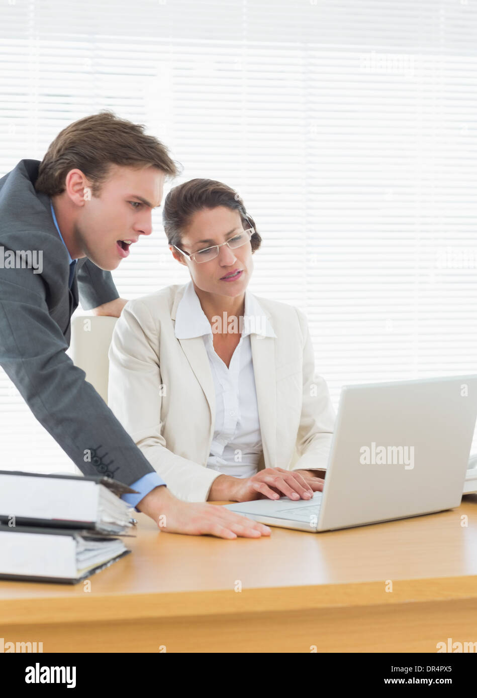 Business couple using laptop at office desk Stock Photo