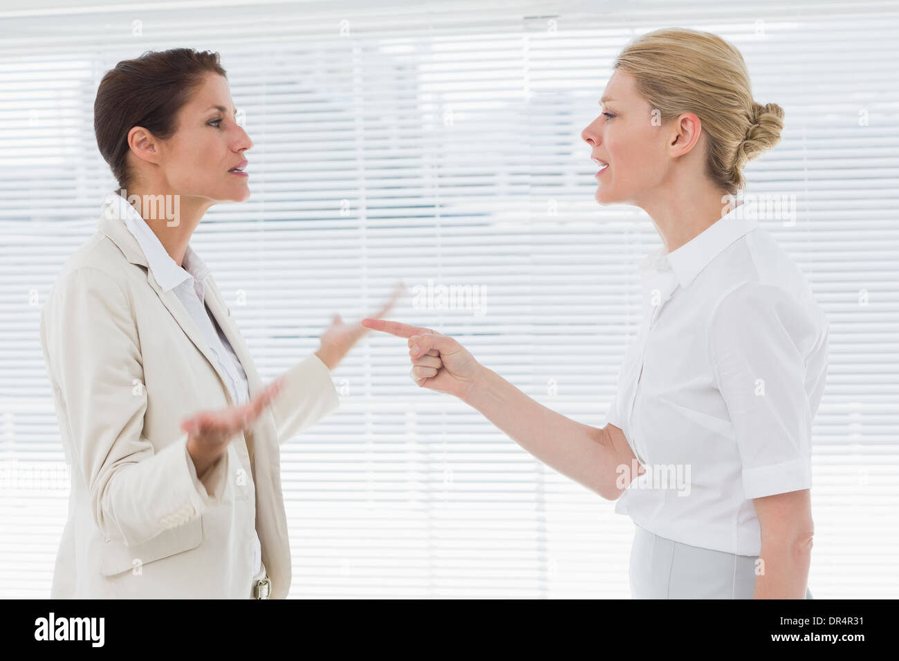 Businesswomen fighting in office Stock Photo