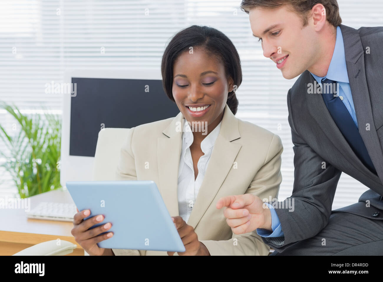 Colleagues using digital tablet in office Stock Photo
