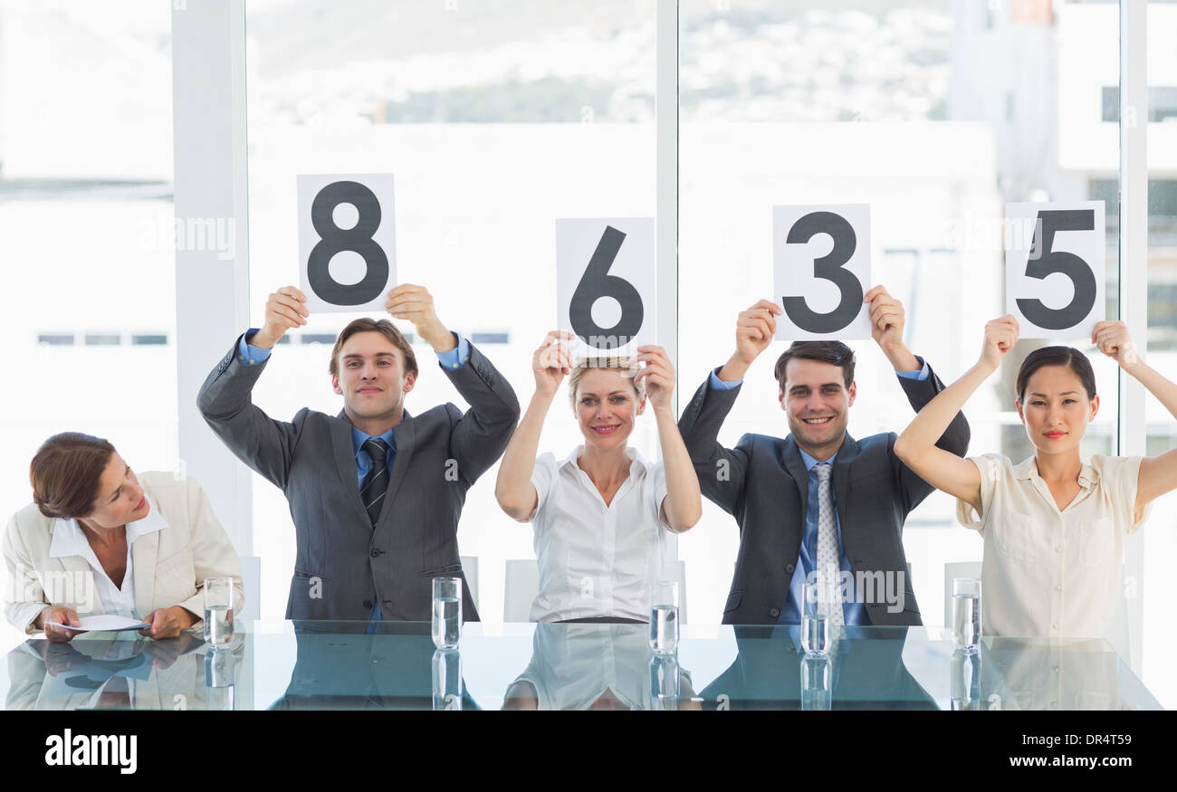 Group of panel judges holding score signs Stock Photo