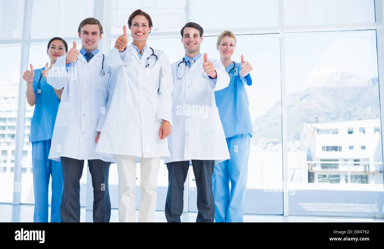 Doctors gesturing thumbs up at hospital Stock Photo