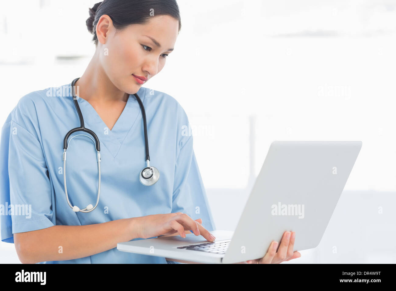 Concentrated surgeon using a laptop in hospital Stock Photo