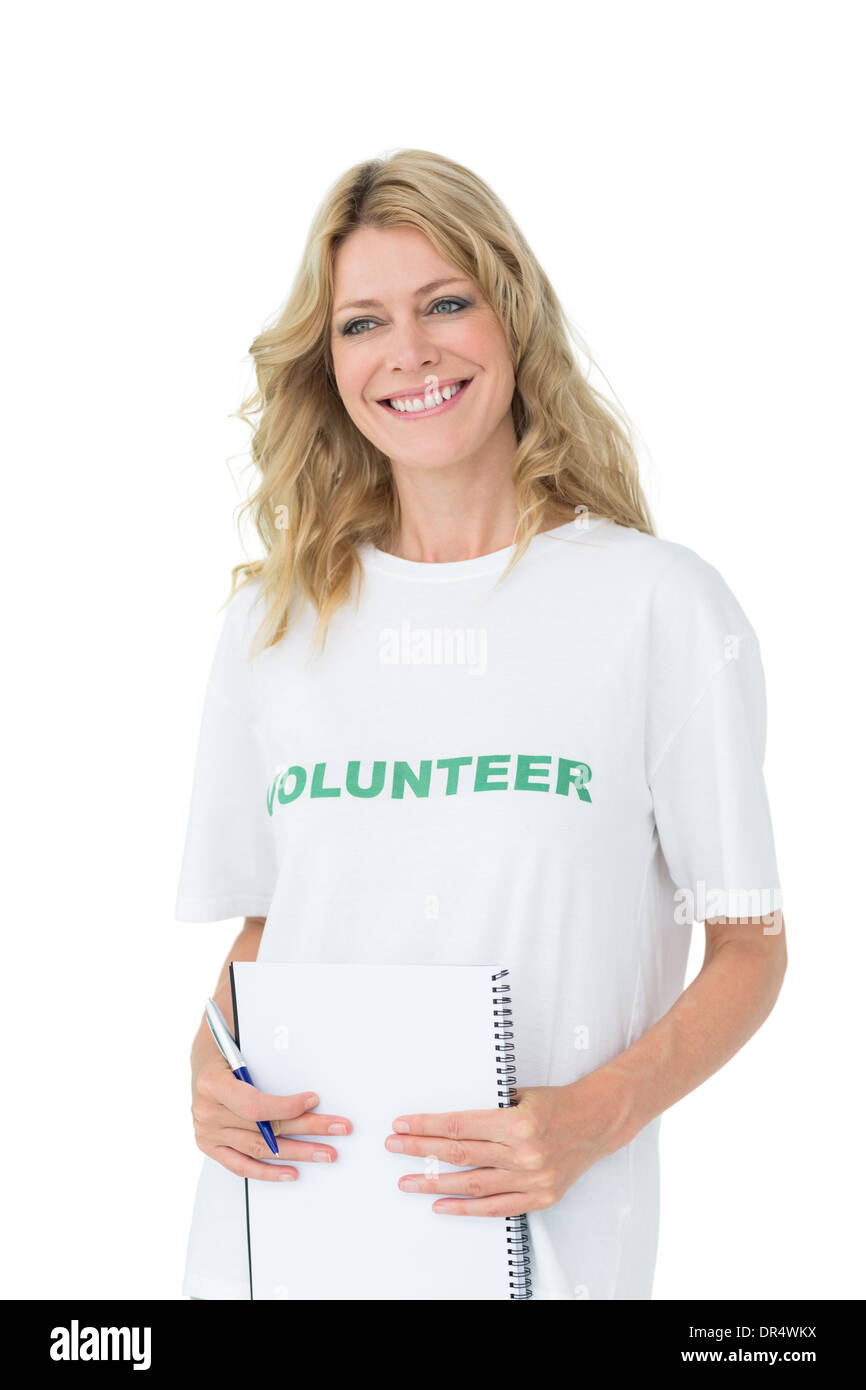 Portrait of a smiling young female volunteer holding clipboard over ...