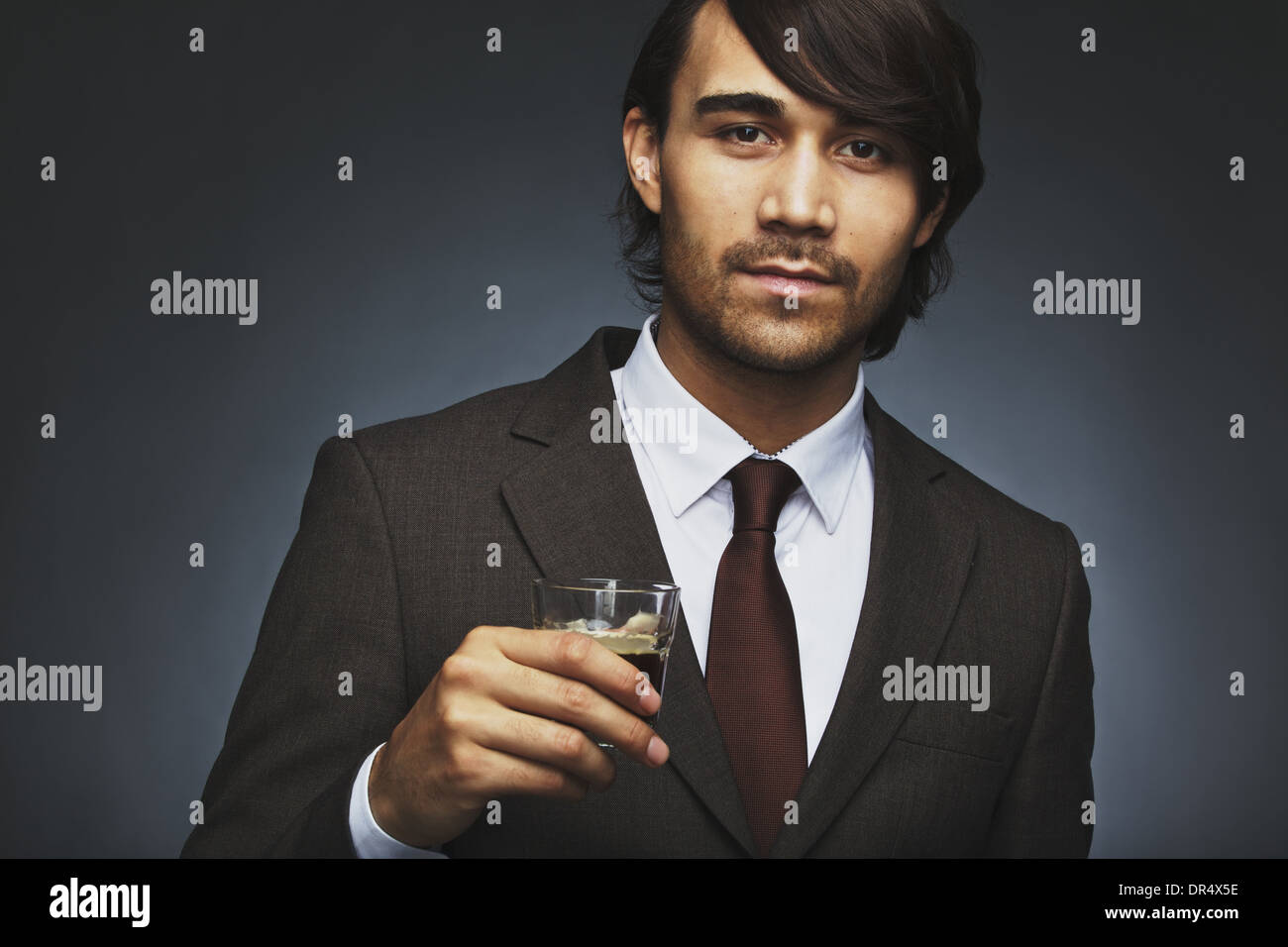 Closeup portrait of attractive young man in business suit holding a cup ...