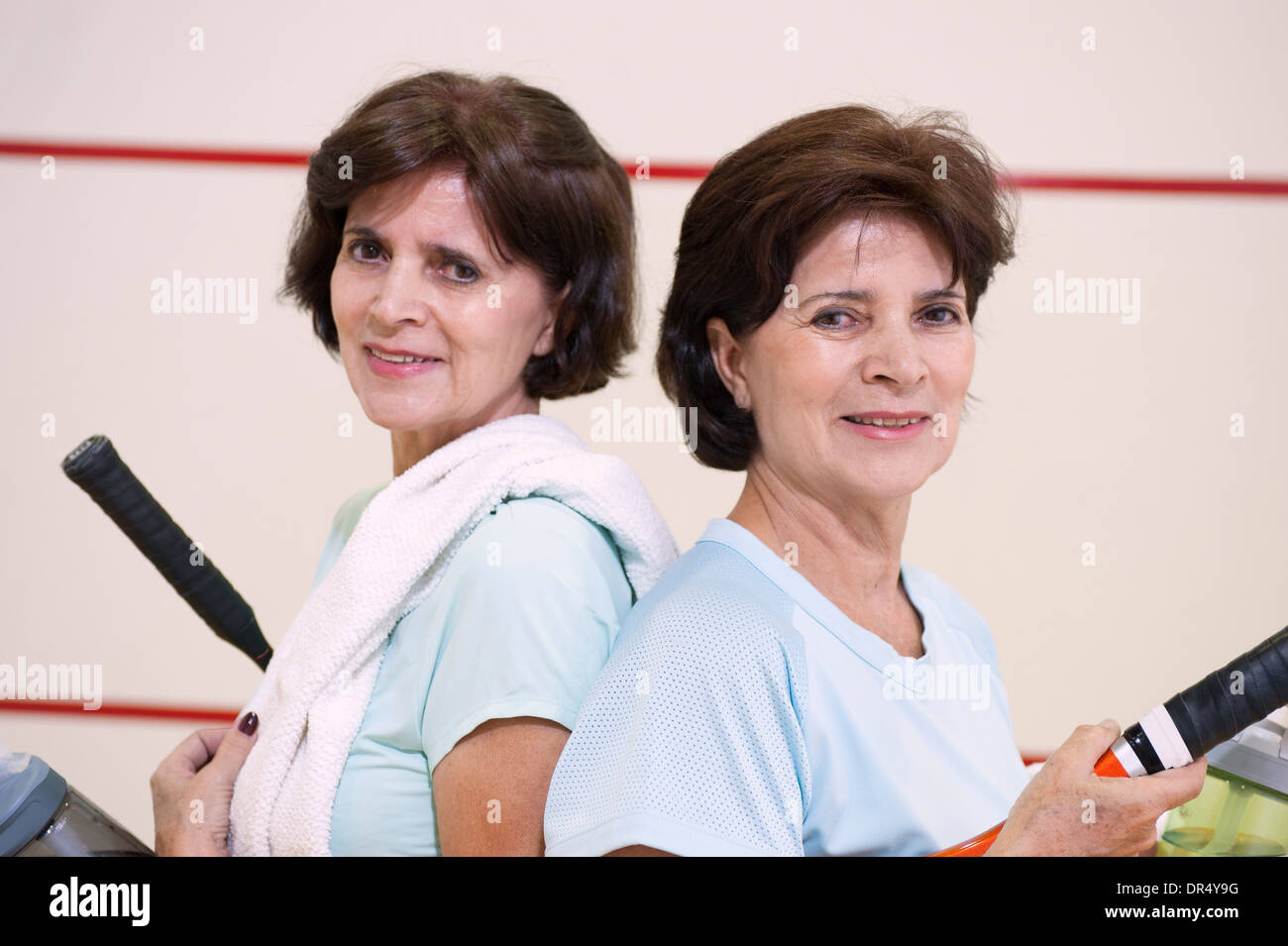Older Hispanic twins playing squash Stock Photo