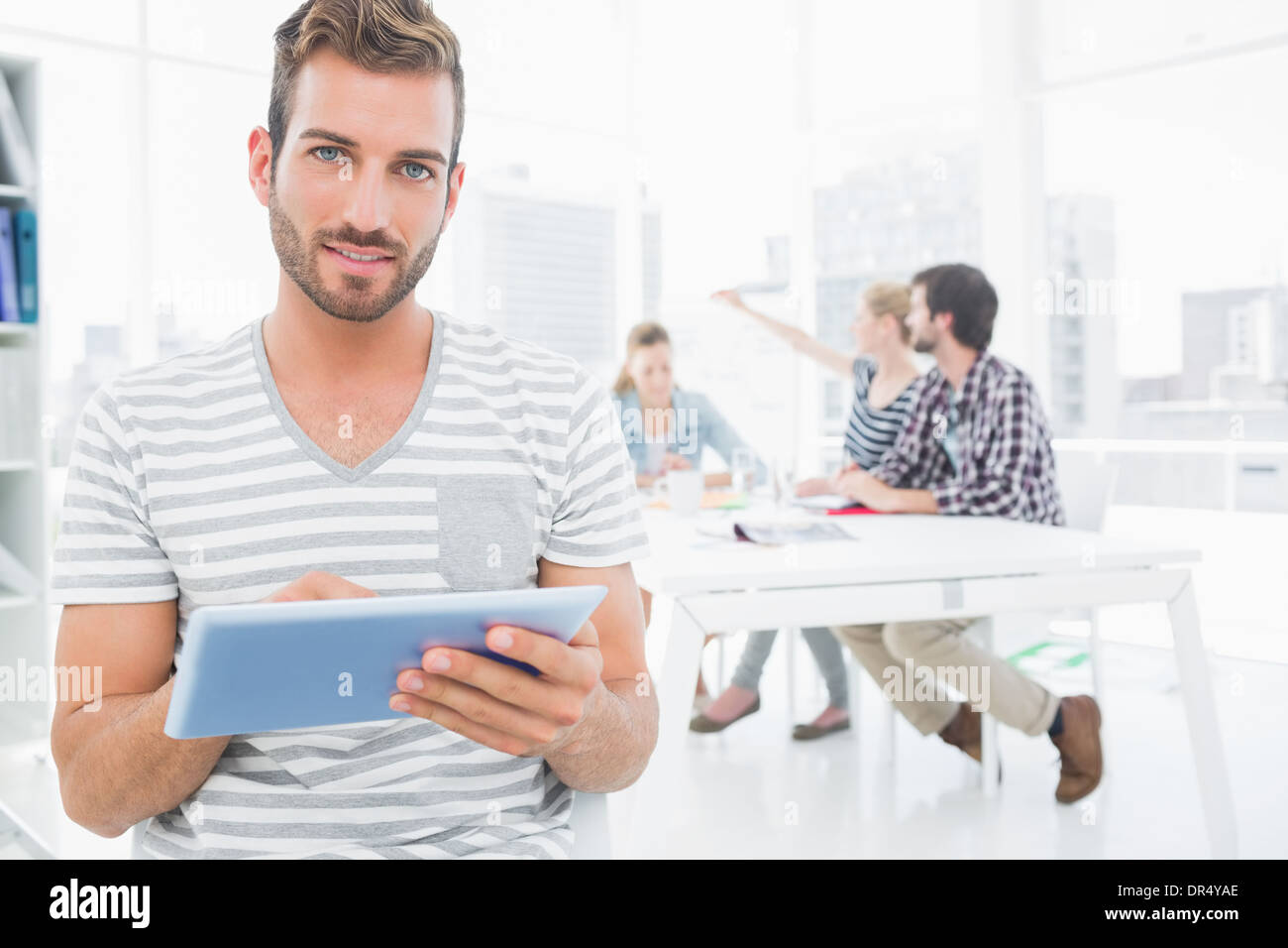 Man using digital tablet with colleagues in background Stock Photo