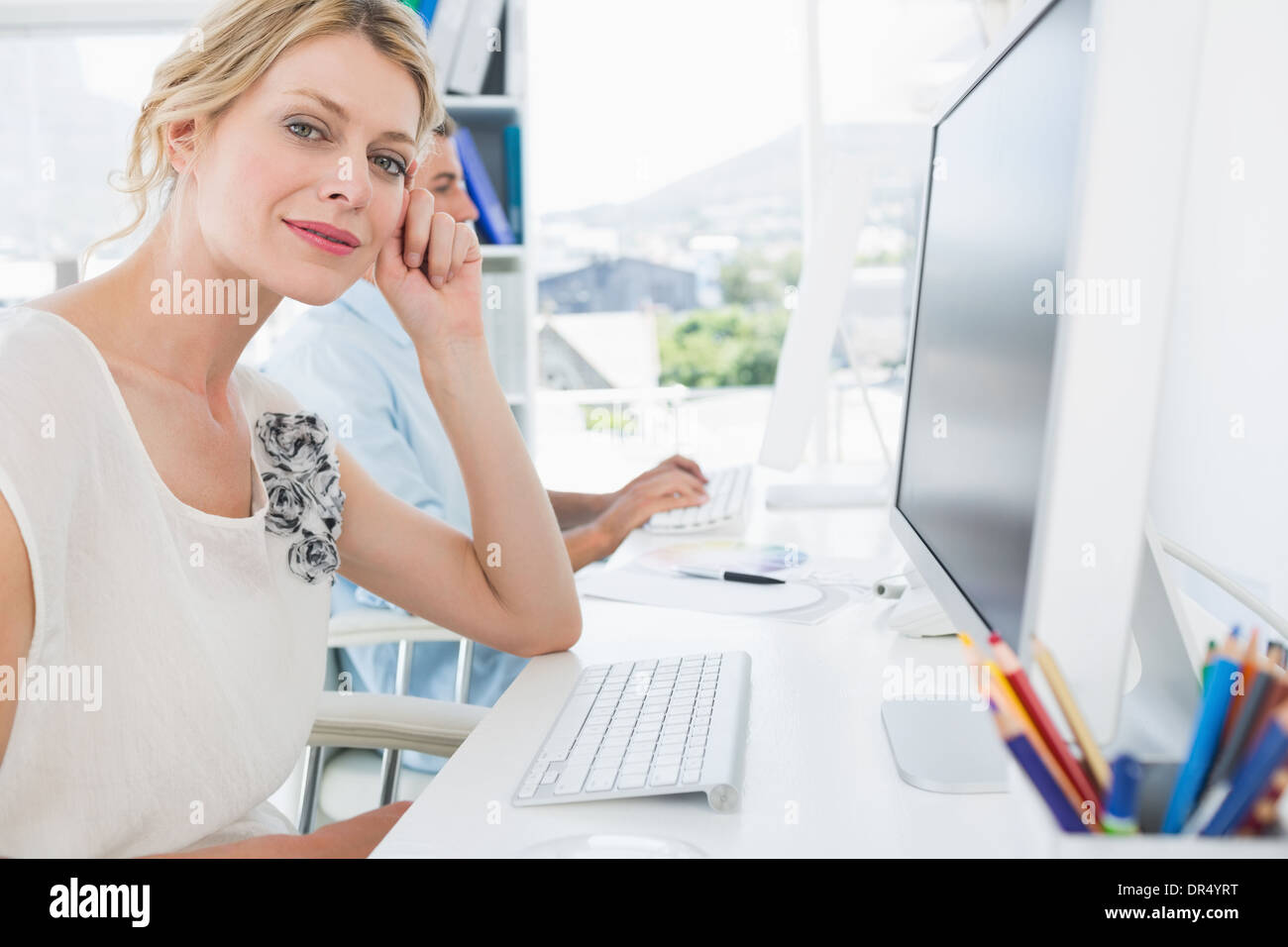 Smiling casual young couple working on computers Stock Photo