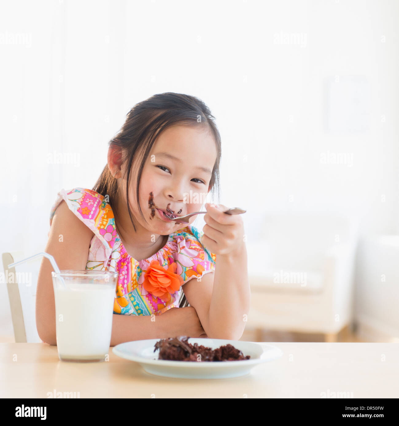 Korean girl eating slice of chocolate cake Stock Photo