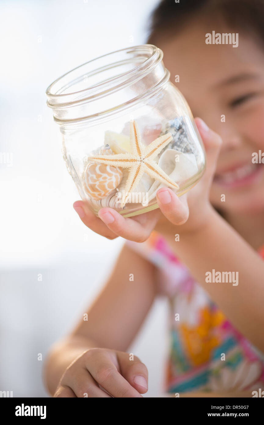 Korean girl examining starfish in jar Stock Photo