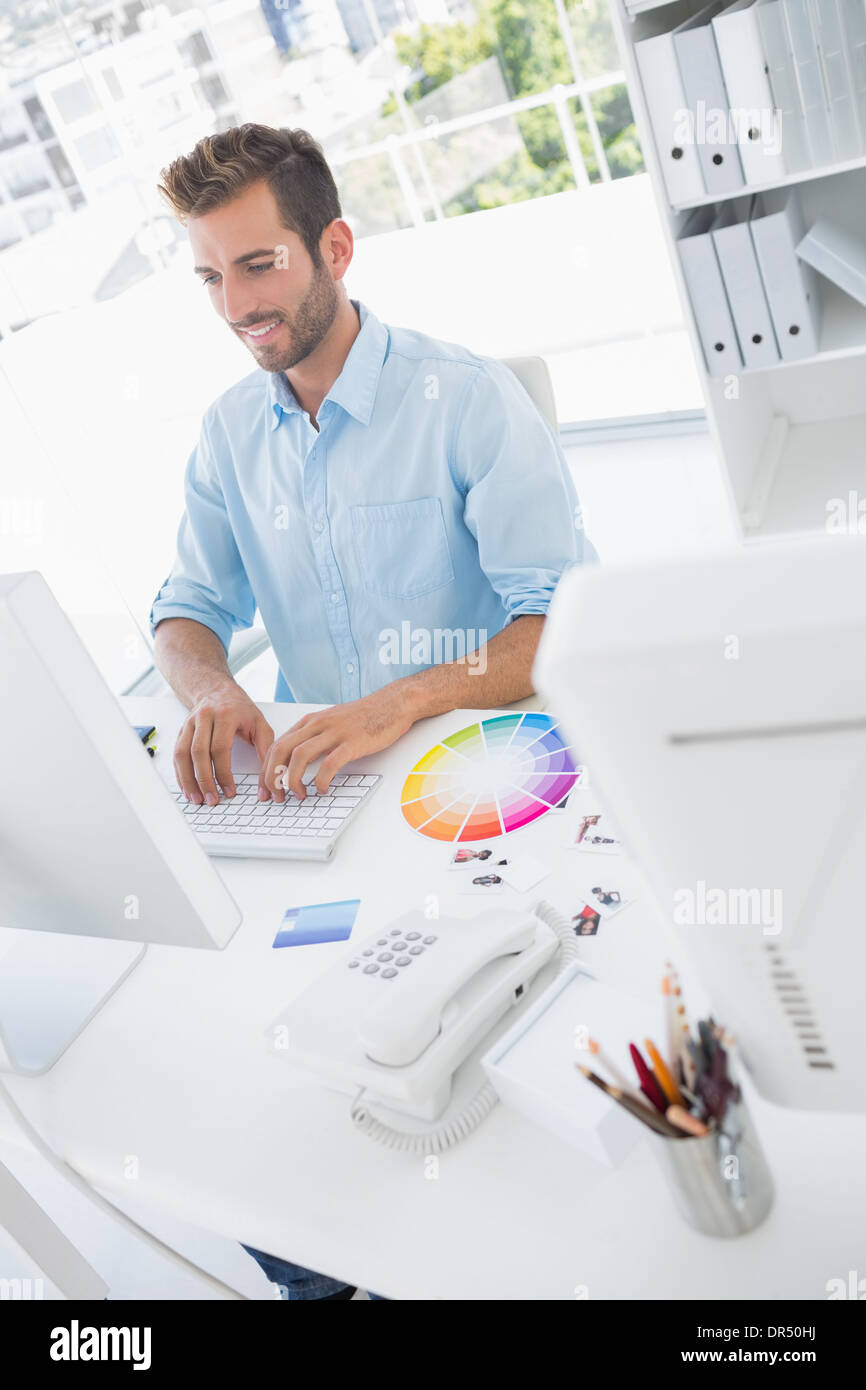 Smiling male photo editor using computer Stock Photo