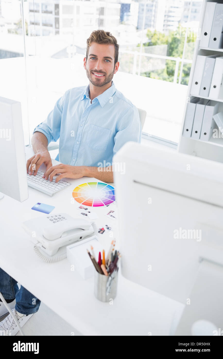 Smiling male photo editor using computer Stock Photo