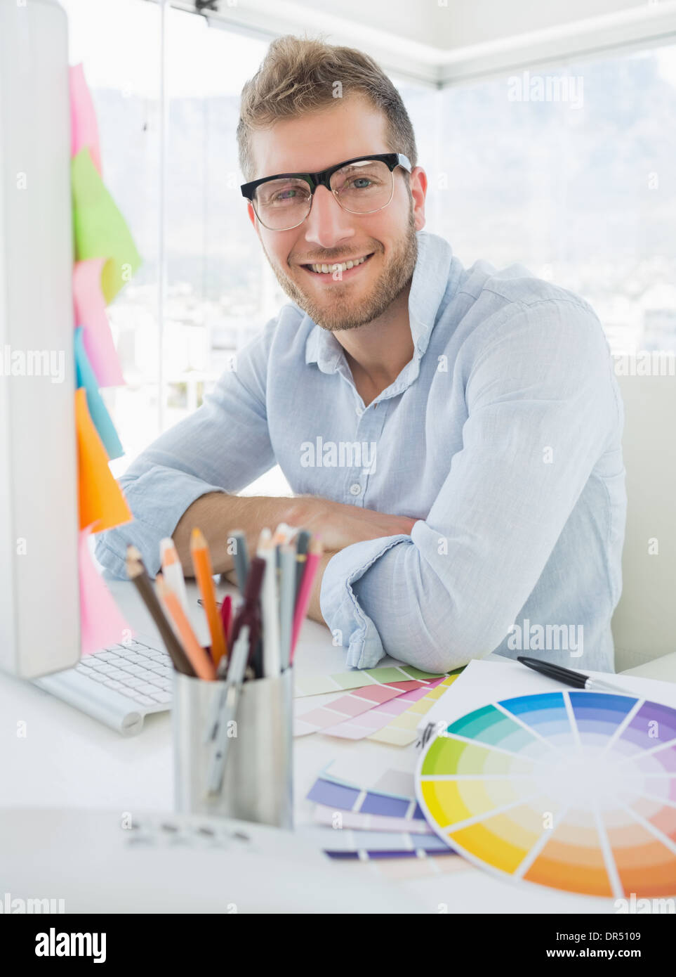 Portrait of a smiling young man using computer Stock Photo