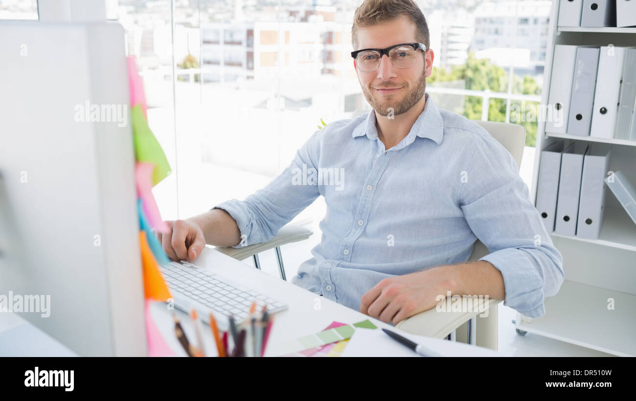 Portrait of a smiling young man using computer Stock Photo