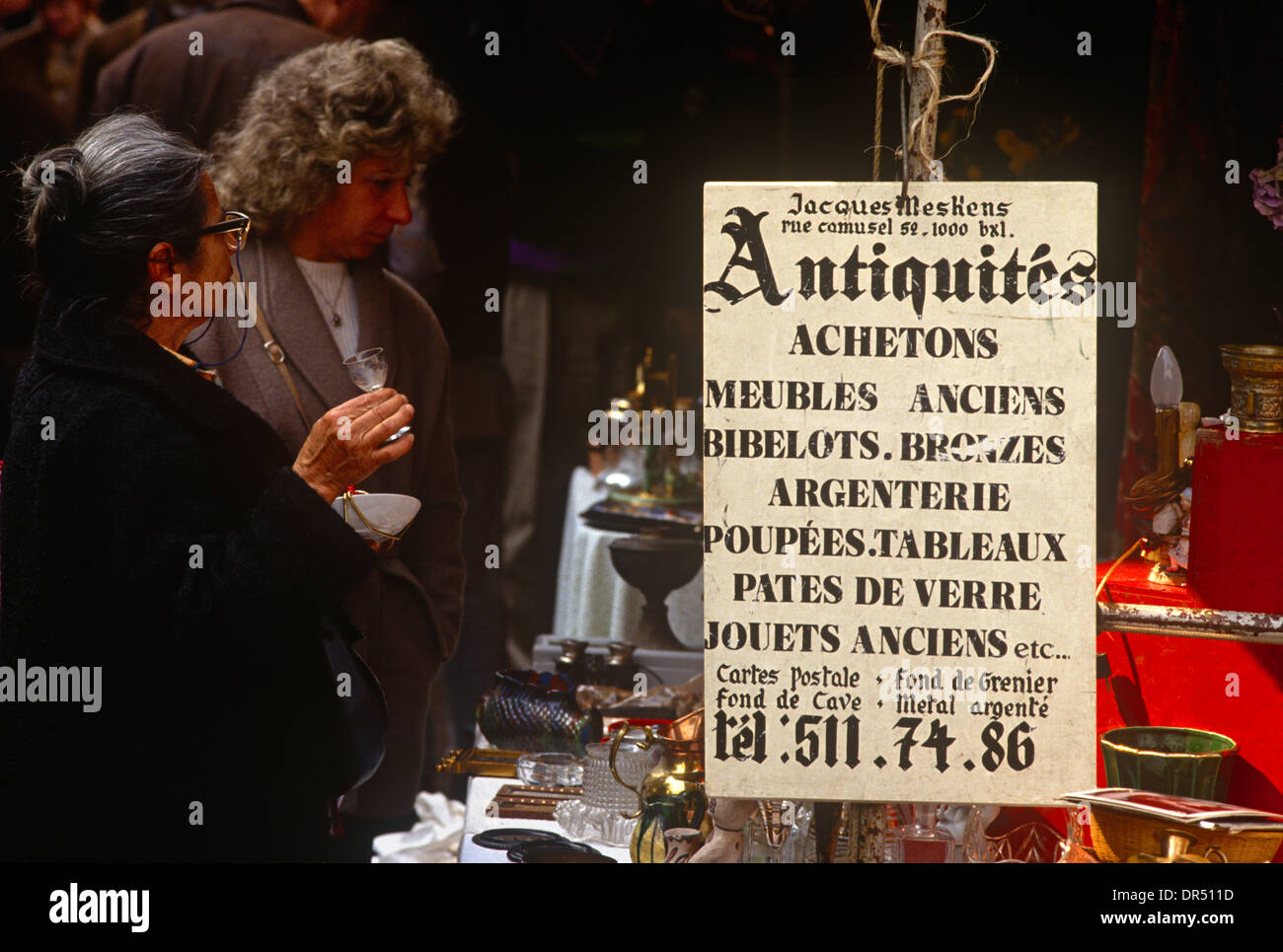 Bargainhunters look through antiques in the flea market at the Marché