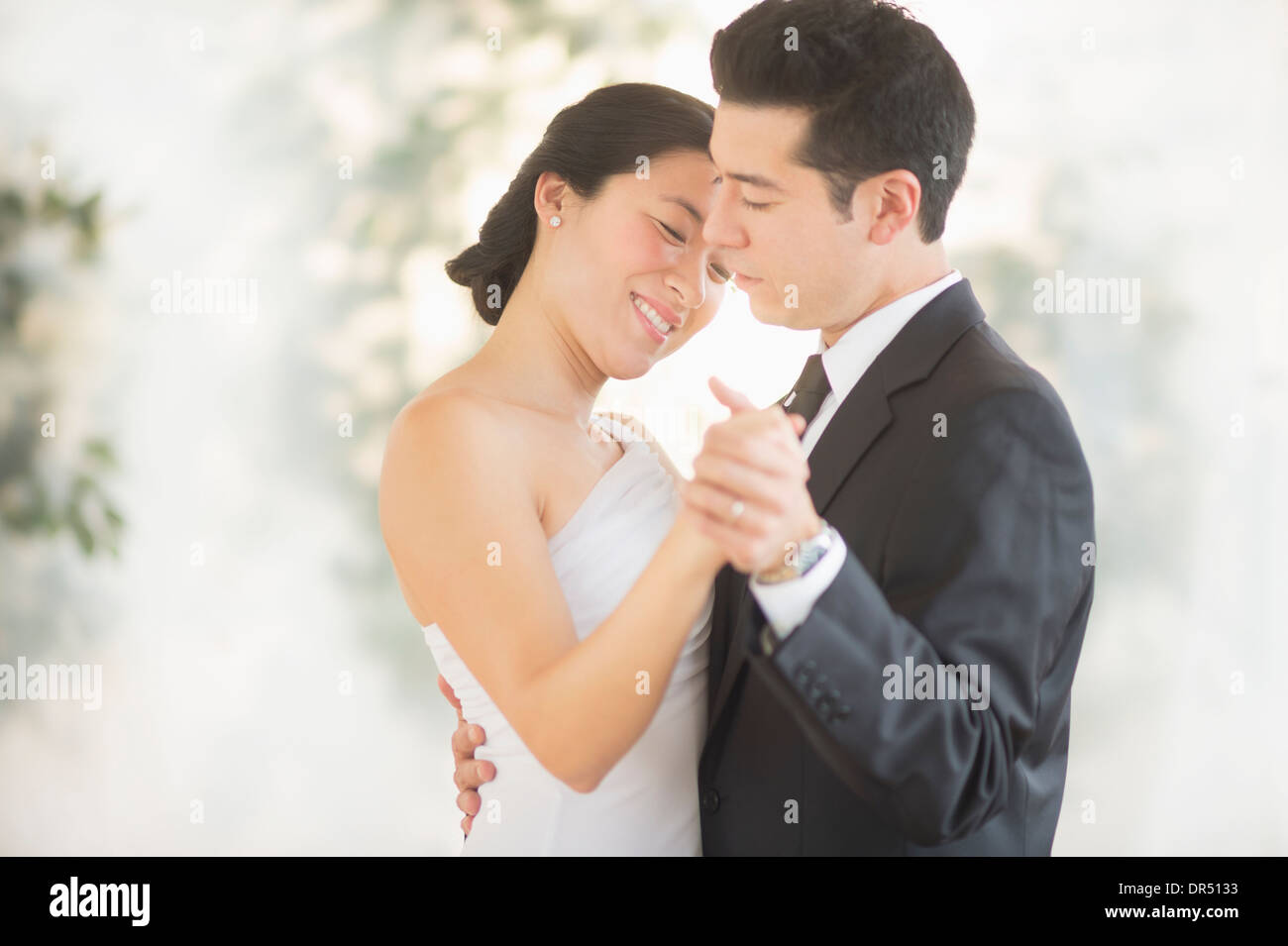 Newlywed couple dancing at wedding reception Stock Photo