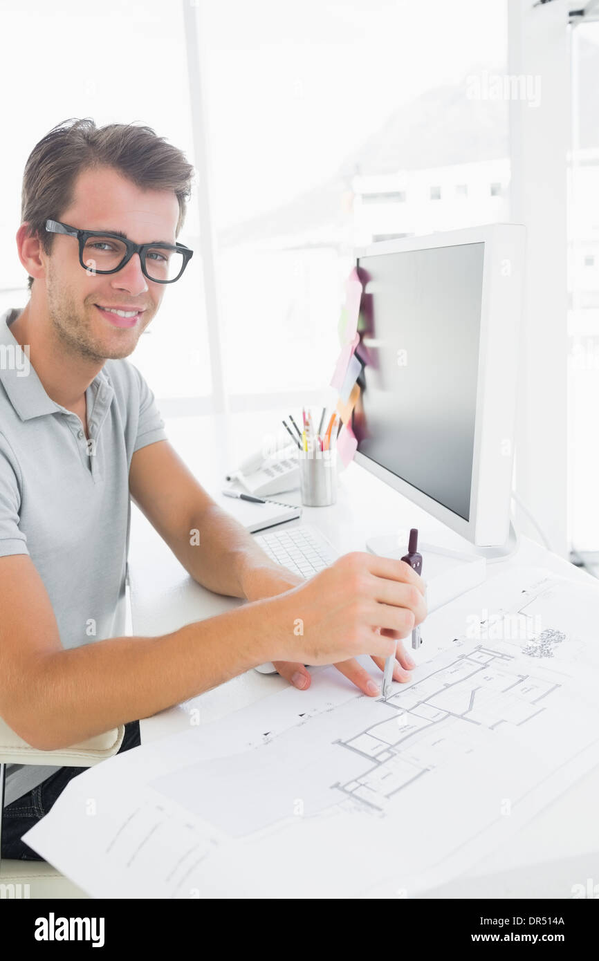Side view of a smiling young man using compass Stock Photo