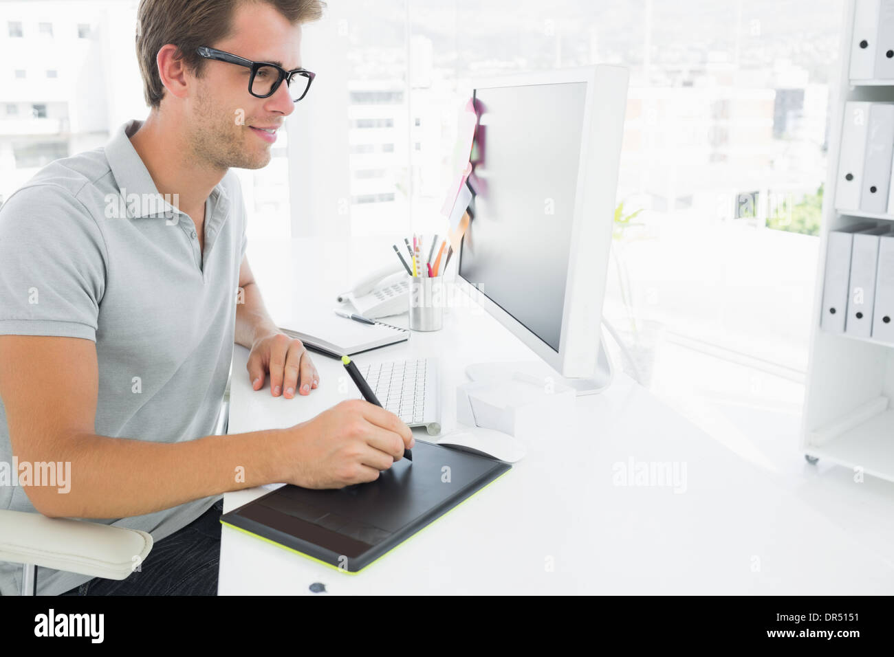 Casual male photo editor using graphics tablet Stock Photo