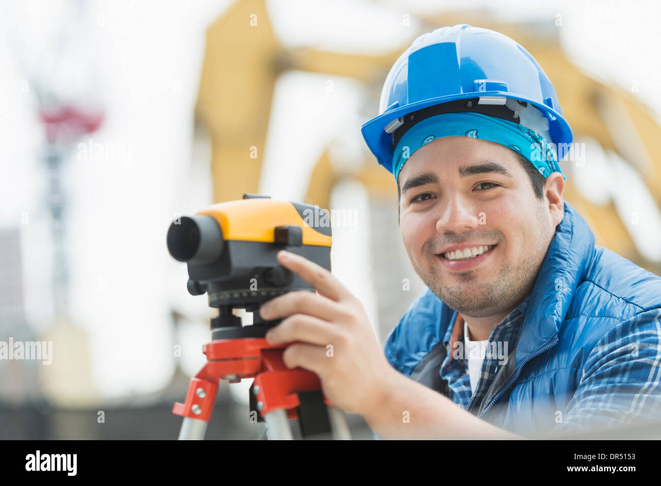 Mixed race engineer using theodolite at construction site Stock Photo
