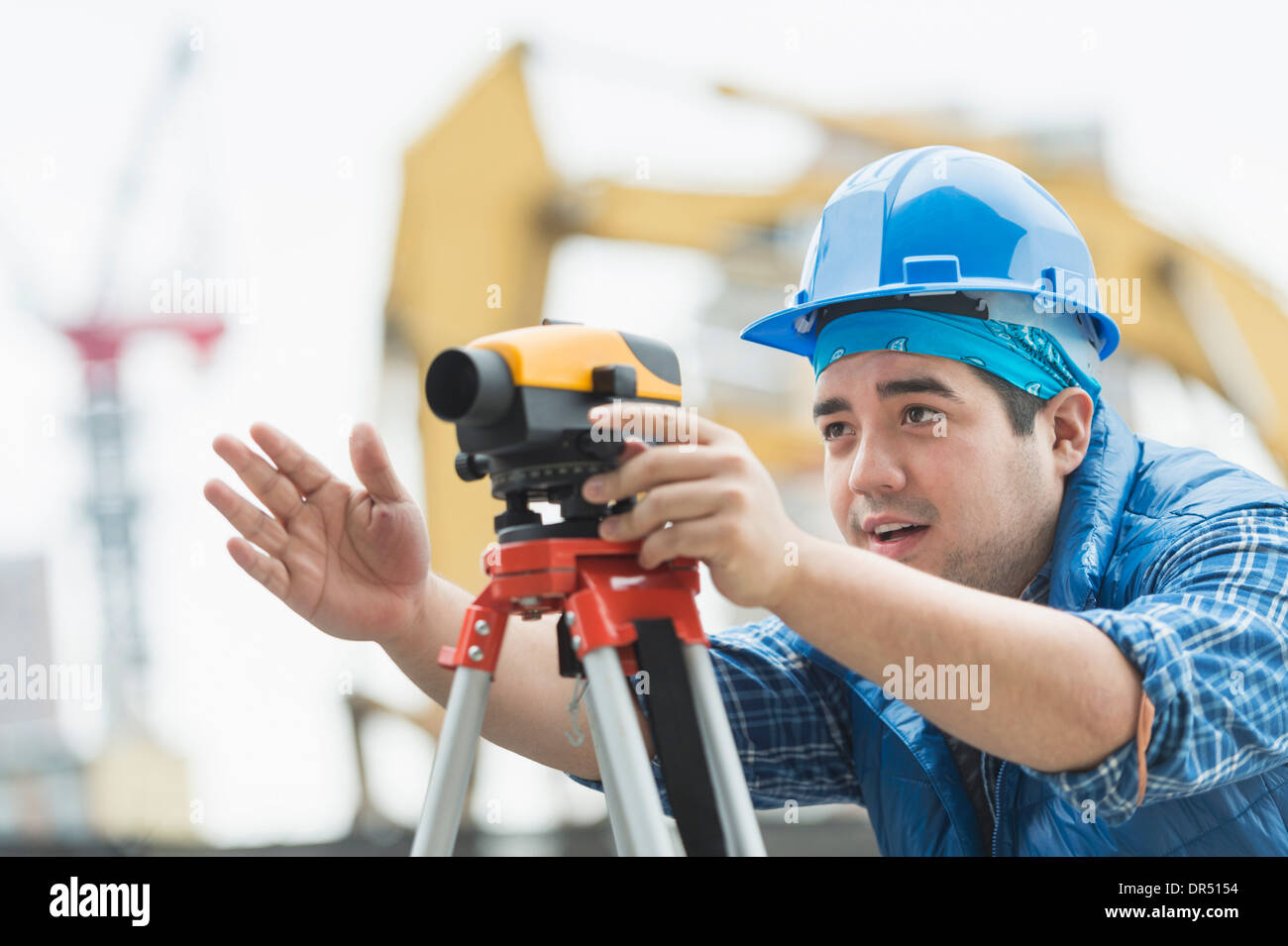 Mixed race engineer using theodolite at construction site Stock Photo